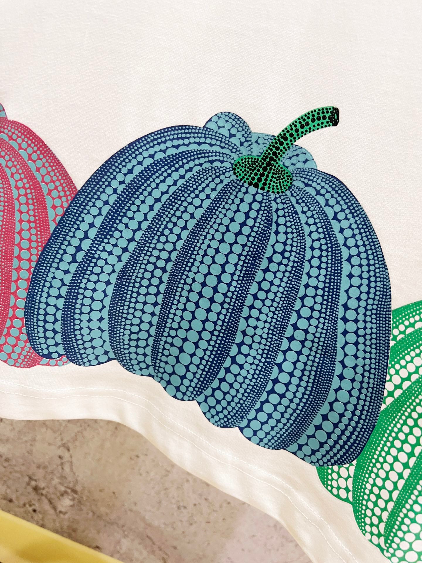White T-shirt with blue, green, and red pumpkin graphic print