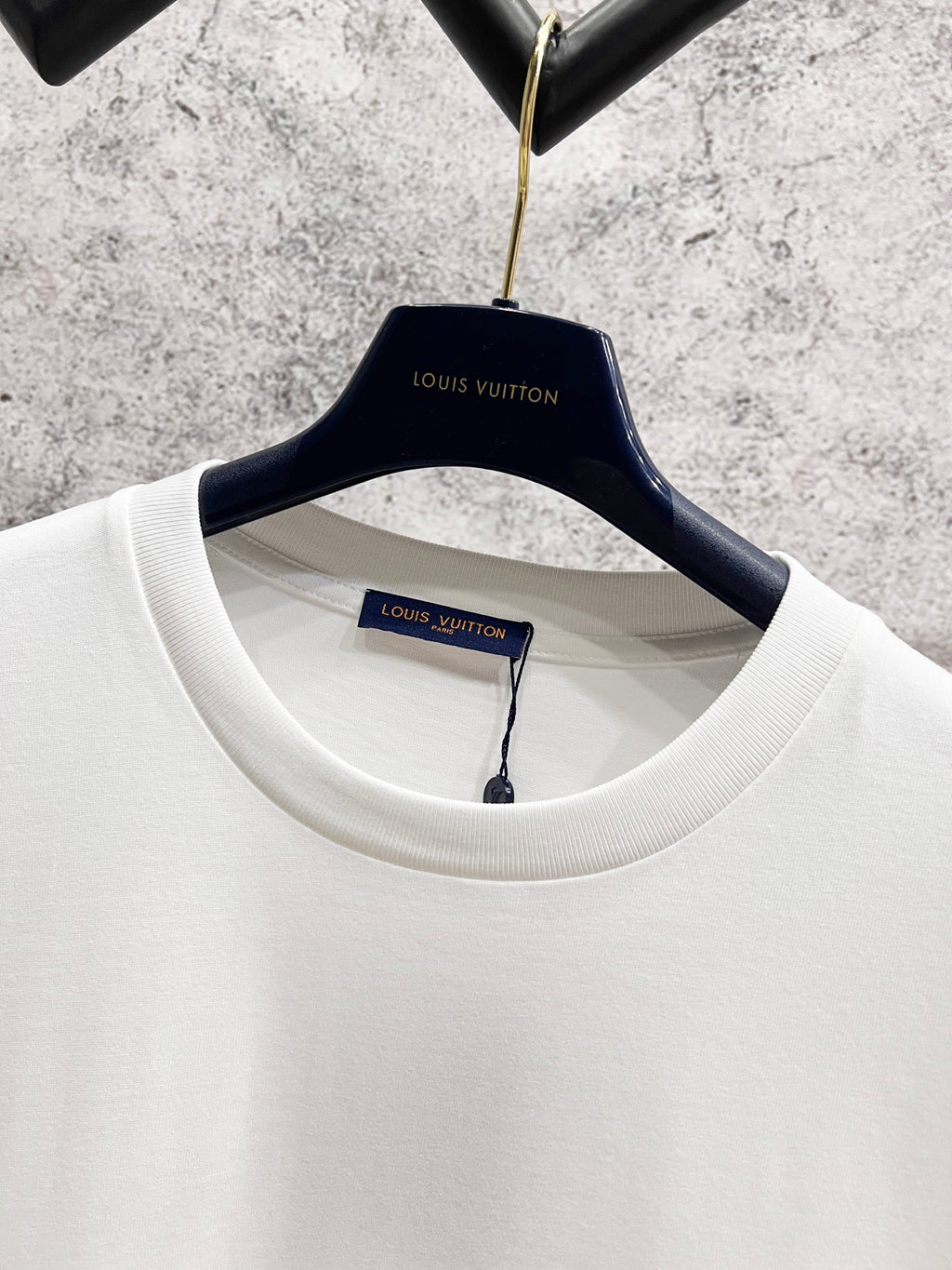 White T-shirt neckline with Louis Vuitton label and blue script logo