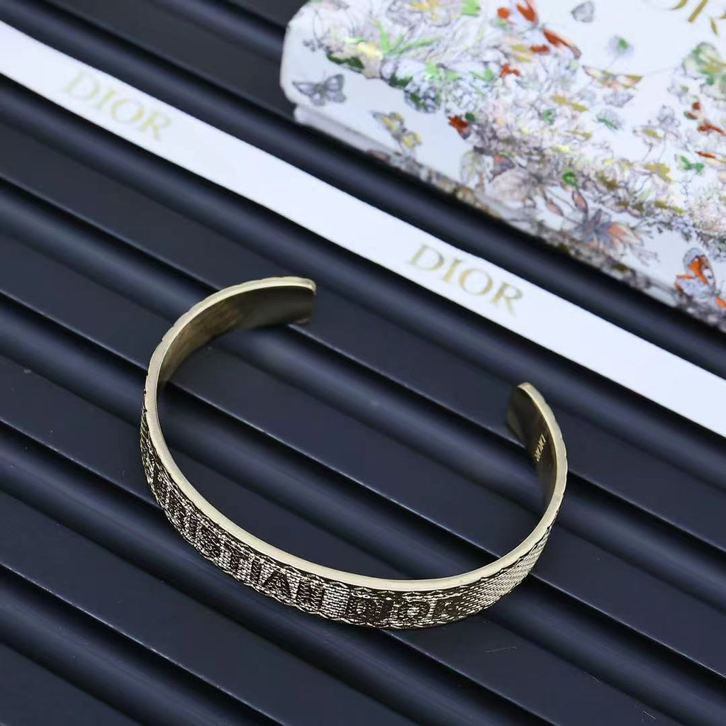 Dior gold-tone cuff bracelet showing engraved band and both open ends