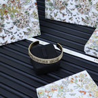 Dior gold-tone textured cuff bracelet on black stand with open ends