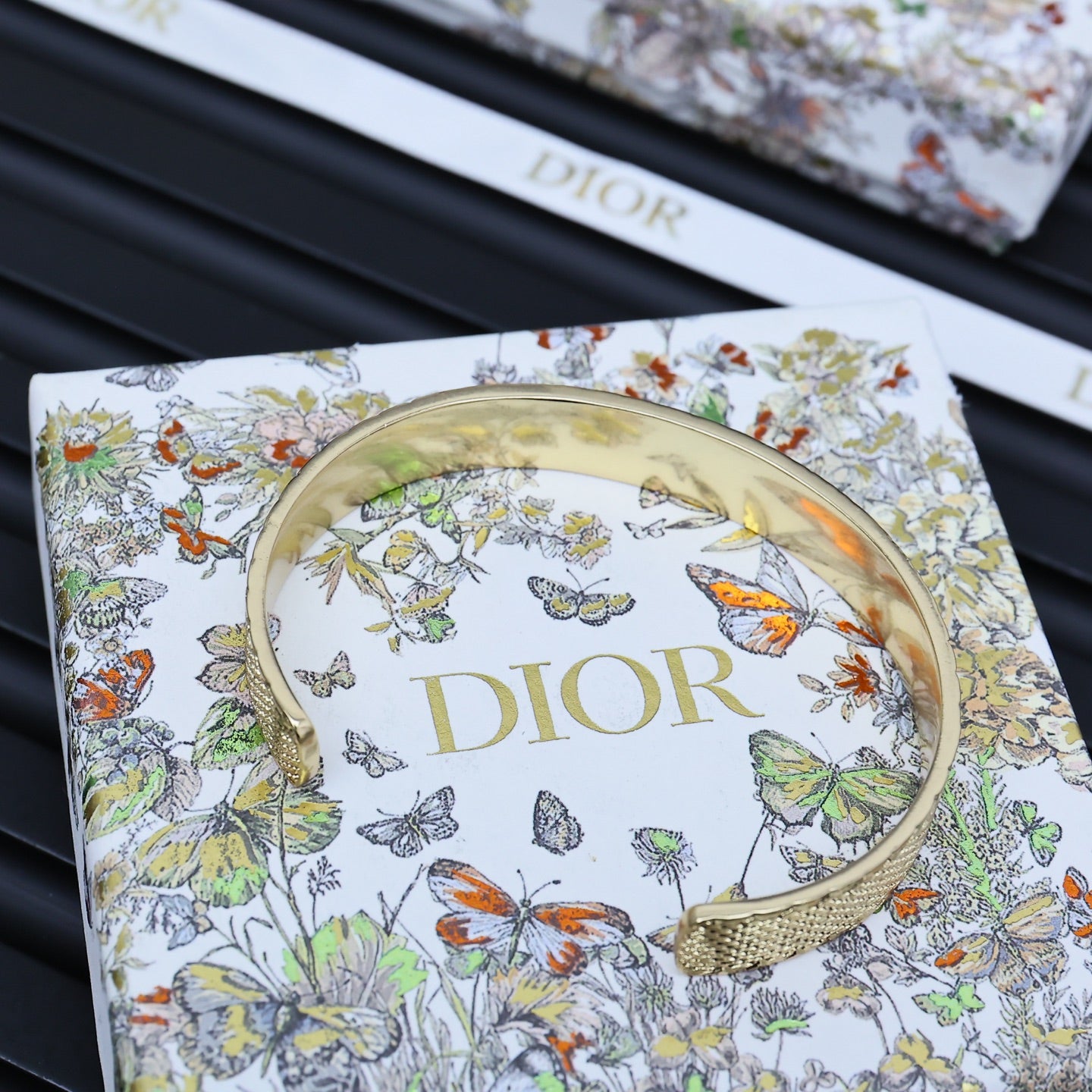 Dior gold-tone cuff bracelet with engraved logo and arched open edge