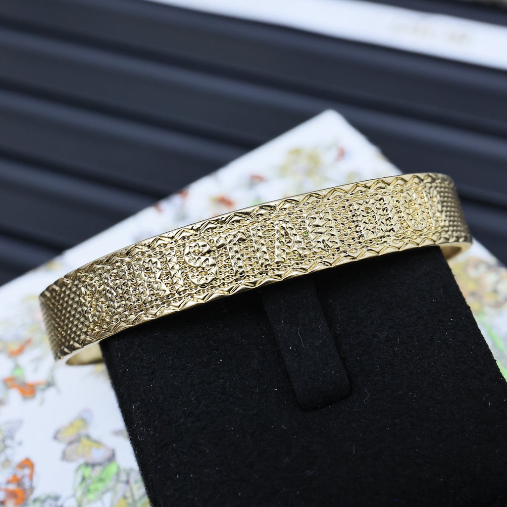 Dior gold-tone textured cuff bracelet on black display stand