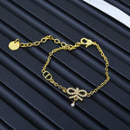 Gold-tone chain bracelet with small charm and round pendant detail