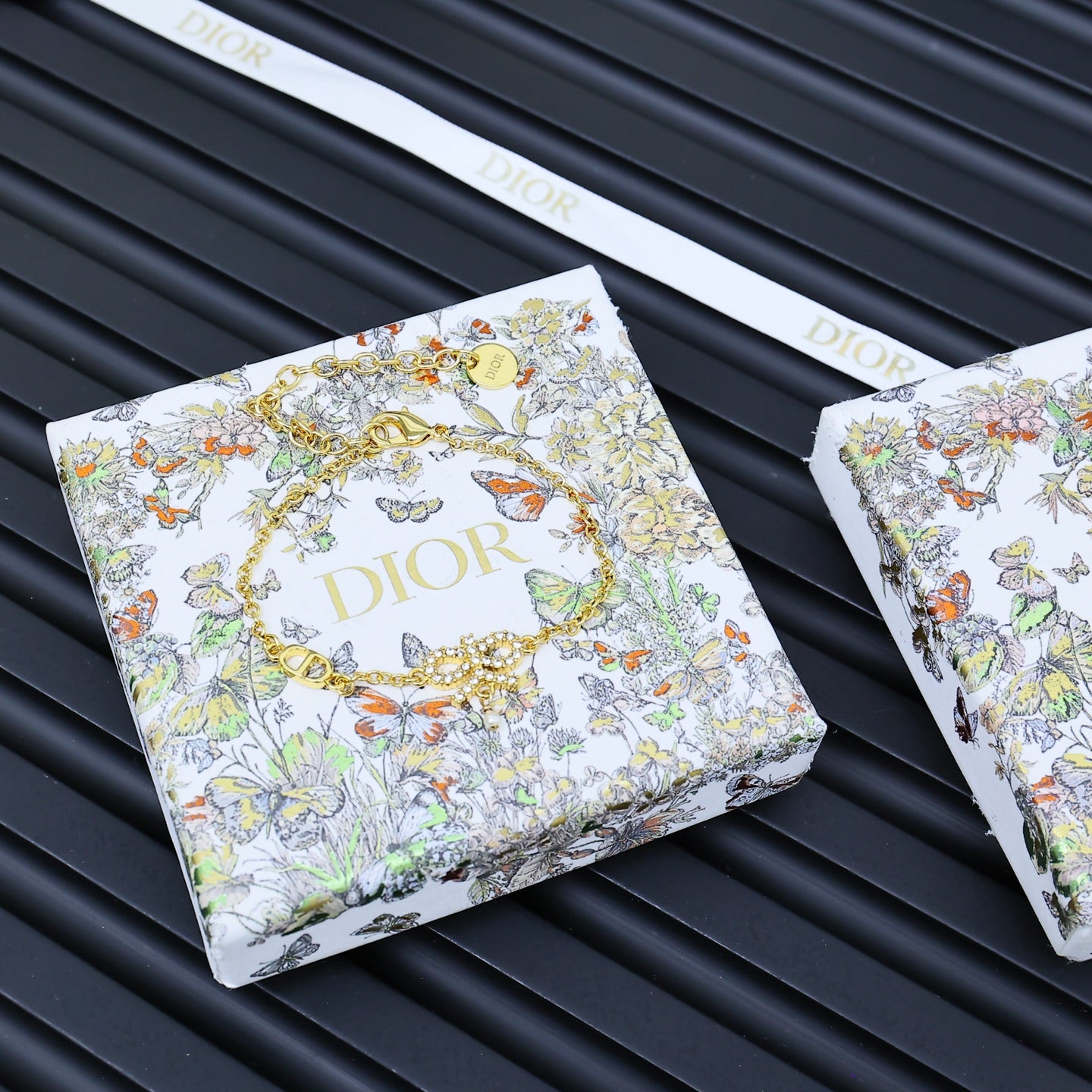 Gold-tone bracelet on floral printed Dior gift cards