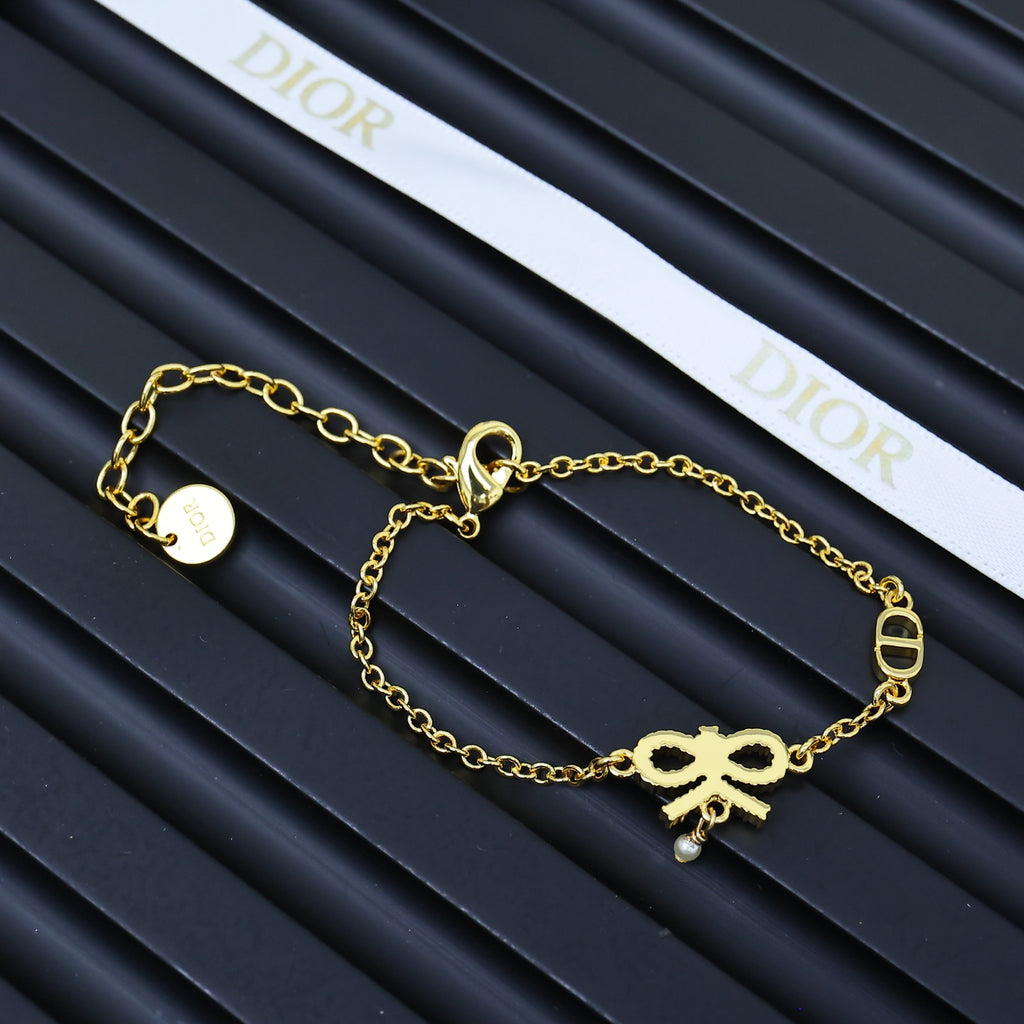 Gold-tone charm bracelet with bow, heart, and round tag