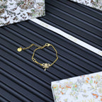 Gold-tone charm bracelet on Dior gift card set