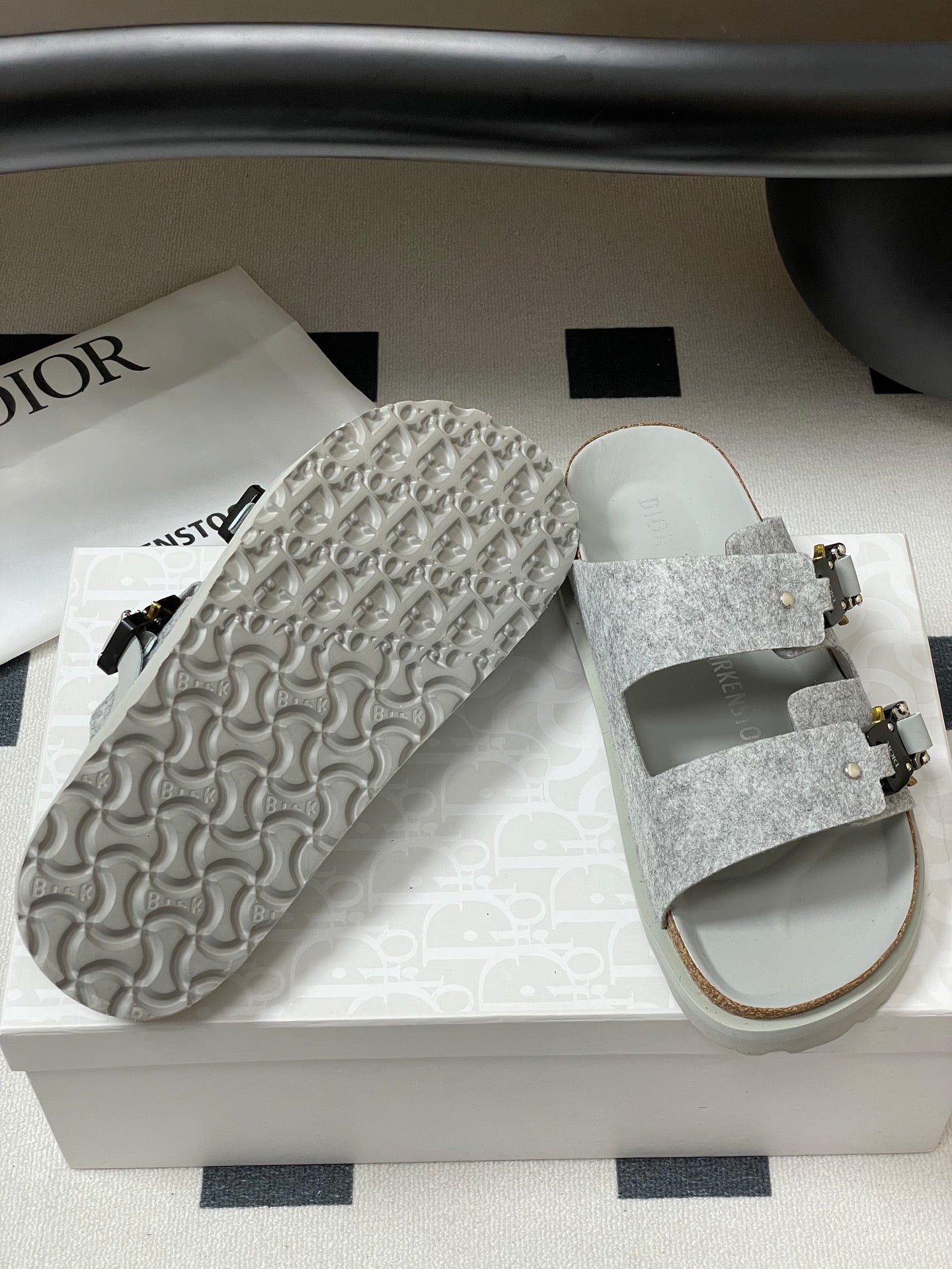 Grey Dior sandals with textured straps and patterned outsole detail on side