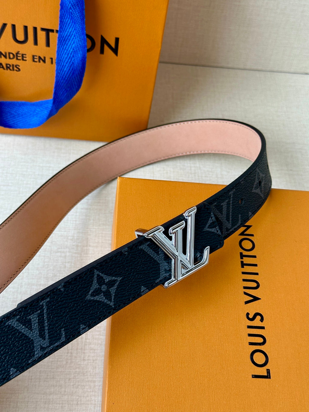 Louis Vuitton monogram belt close-up with LV buckle on dark strap