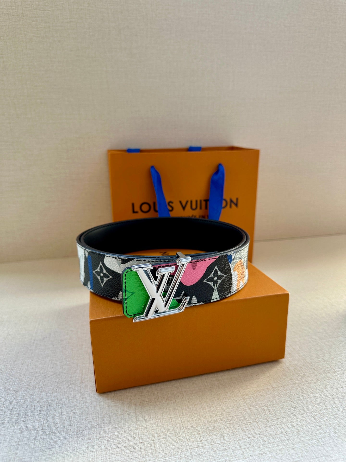 Louis Vuitton belt with black base strap and multicolor graphic panel plus gold LV buckle
