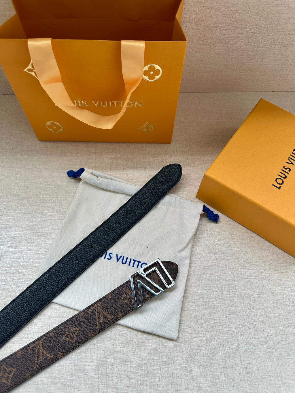 Louis Vuitton monogram belt with LV silver buckle on dark strap detail
