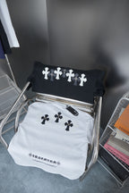 Folded white and black T-shirts with dark cross prints