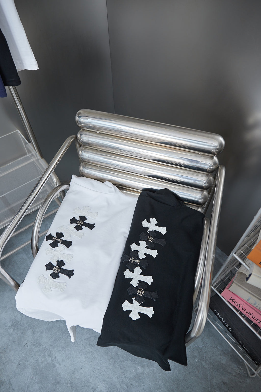 Folded T-shirts in white and black with white cross motifs on the fronts