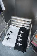 Folded T-shirts in white and black with white cross motifs on the fronts