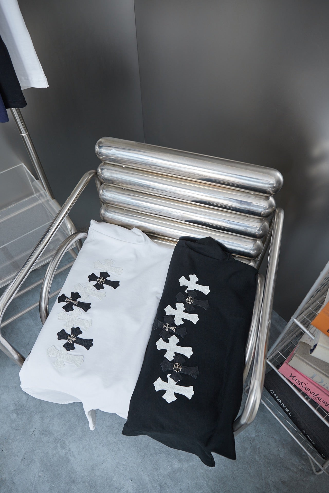 Folded T-shirts in white and black with white cross motifs on the fronts