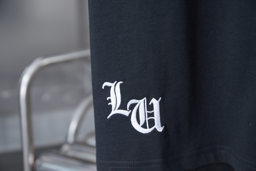 Black T-shirt with white emblem logo near the side hem
