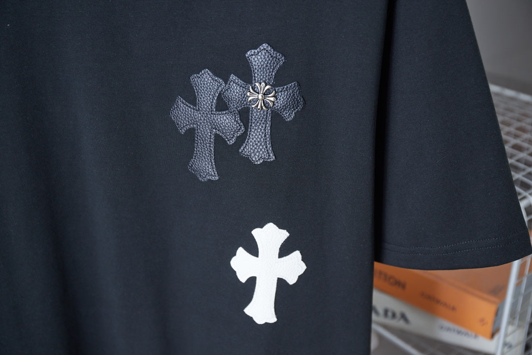Black T-shirt with white and silver-tone cross prints on the chest