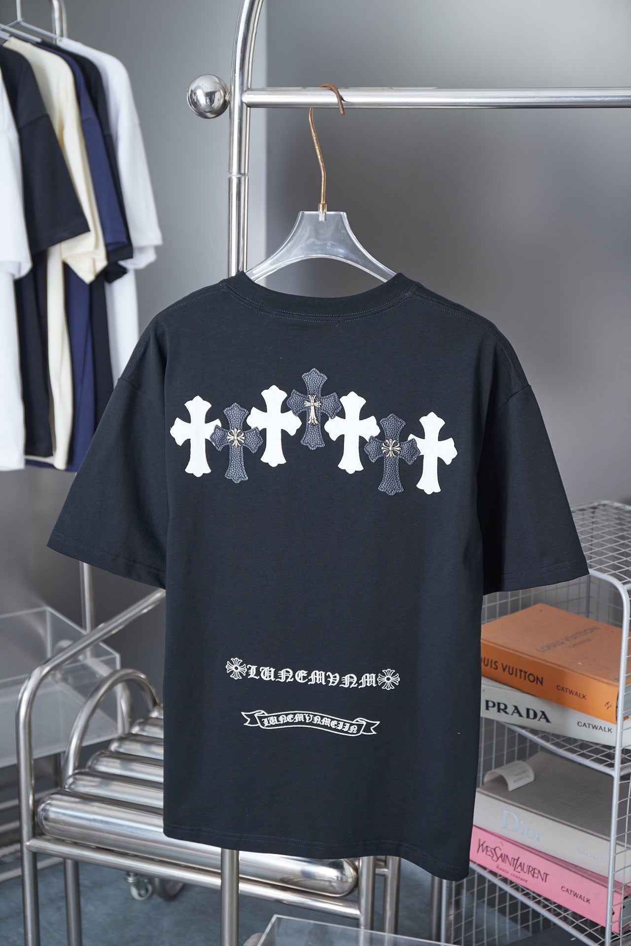 Black short-sleeve T-shirt with row of white cross graphics and small text