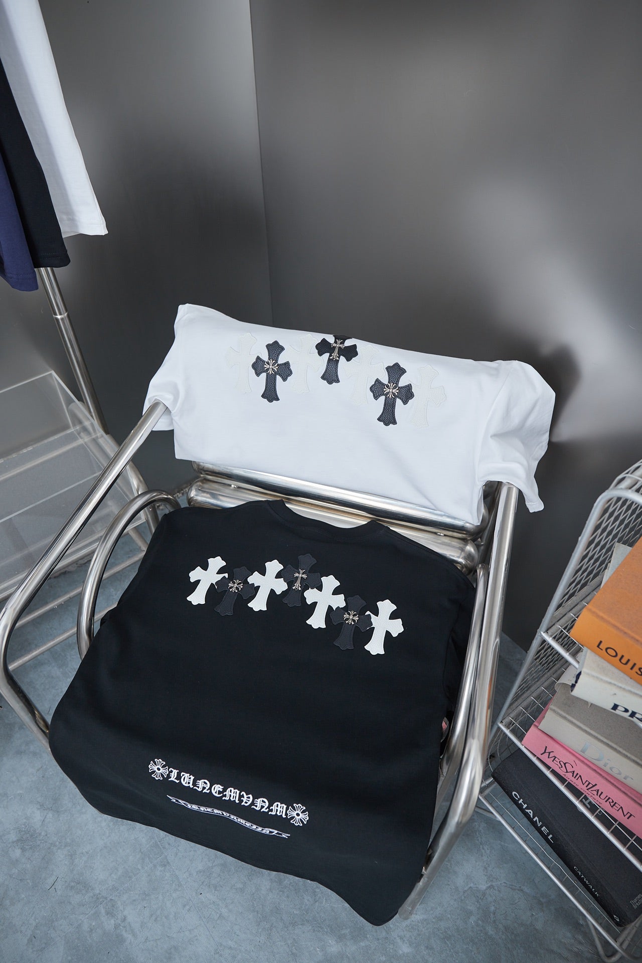 Folded shirts: white and black short-sleeve T-shirts with small cross graphics