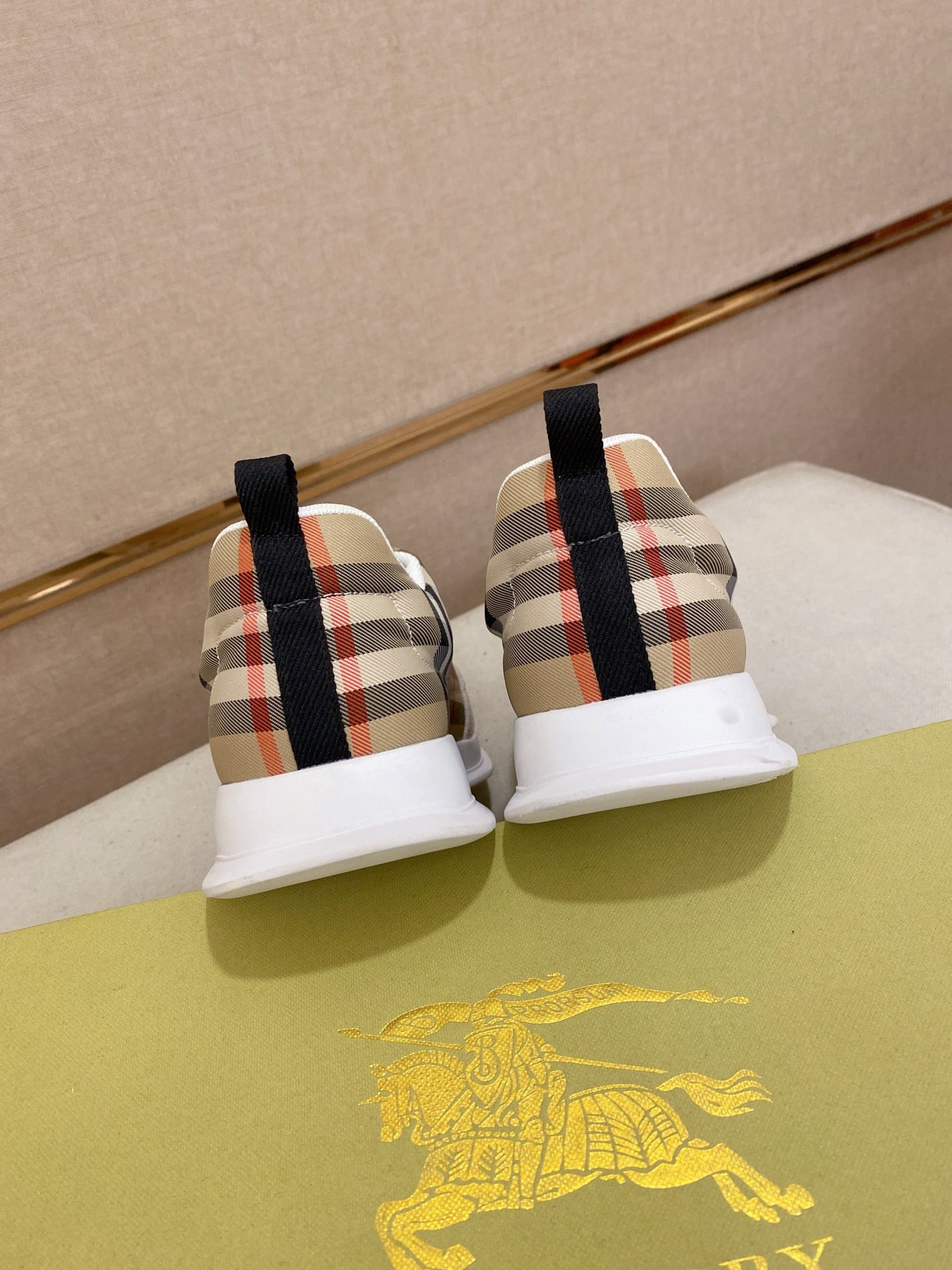 Back view of plaid canvas sneakers with black heel tabs and white soles.