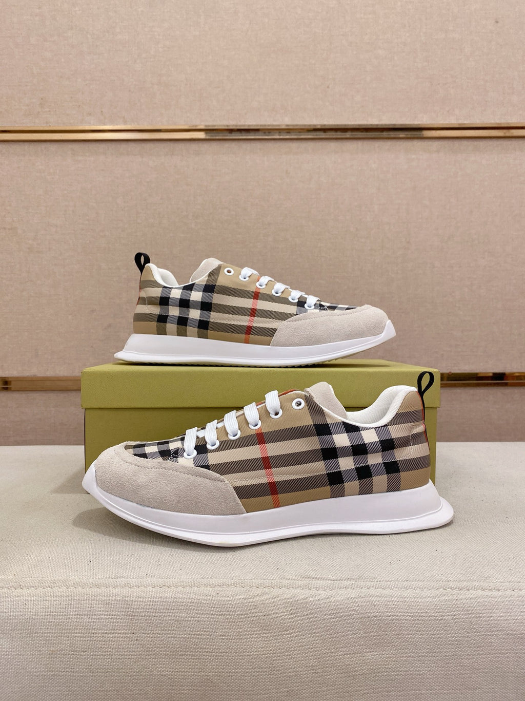 Pair of plaid canvas low-top sneakers on a green box with white soles and laces.