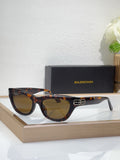 Balenciaga sunglasses, dark tortoise frame, gold B detail, amber-tinted lenses
