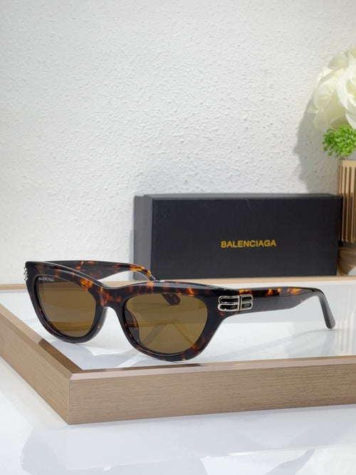 Balenciaga sunglasses, dark tortoise frame, gold B detail, amber-tinted lenses