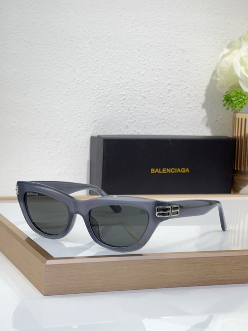 Balenciaga sunglasses, dark blue-gray frame, gold B bar detail, smoky lenses