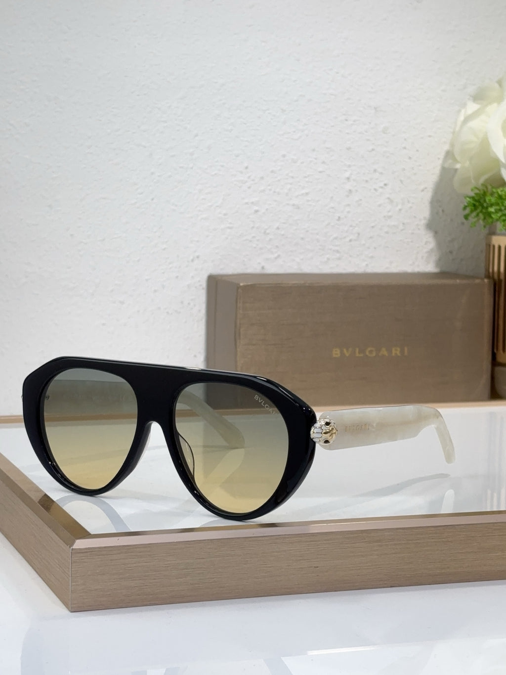 Bvlgari sunglasses with black frames and yellow-green mirrored lenses, round cat-eye style
