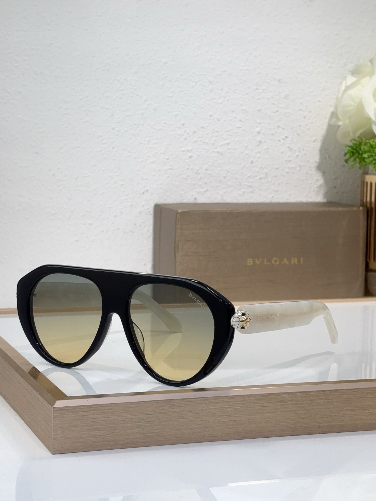 Bvlgari sunglasses with black frames and yellow-green mirrored lenses, round cat-eye style