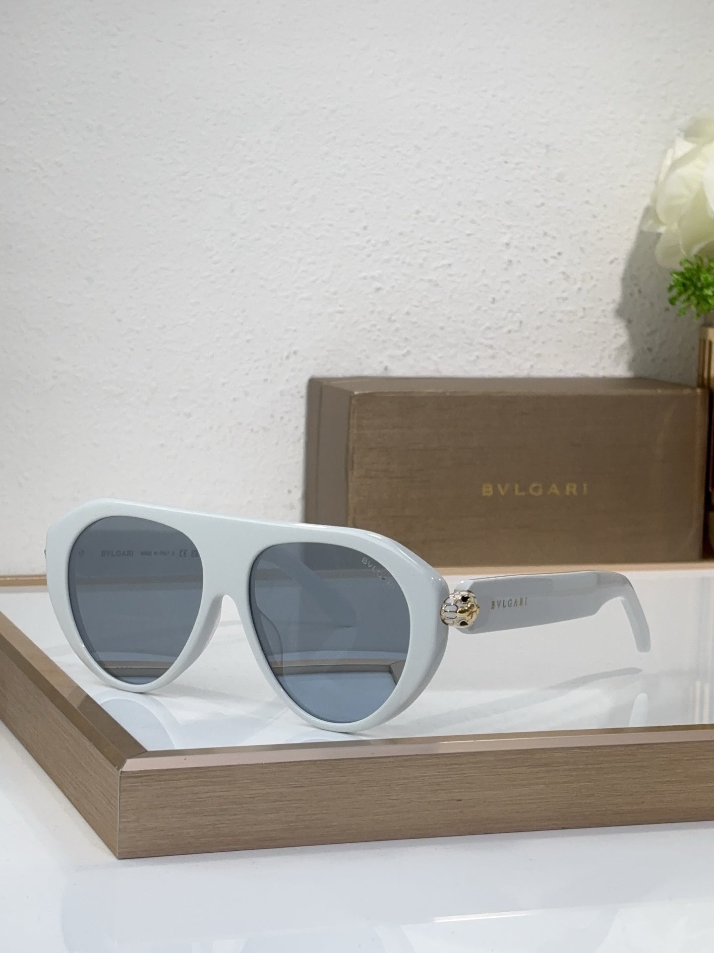 Bvlgari sunglasses with white frames and blue mirrored lenses, round cat-eye style