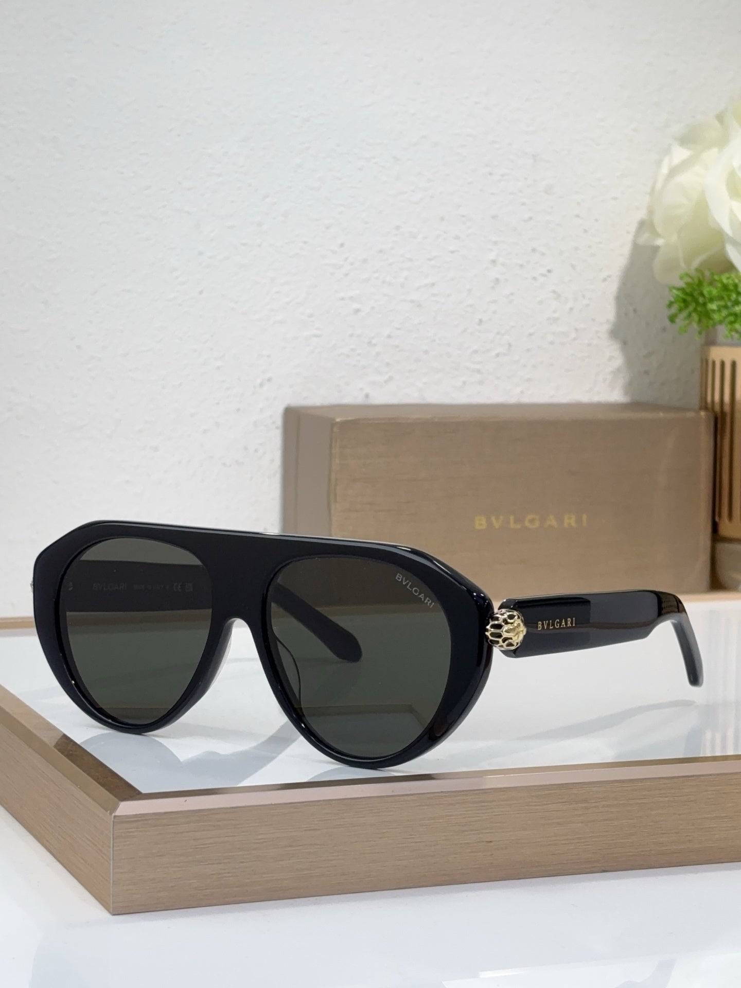 Bvlgari sunglasses with black frames and dark mirrored lenses, round cat-eye style