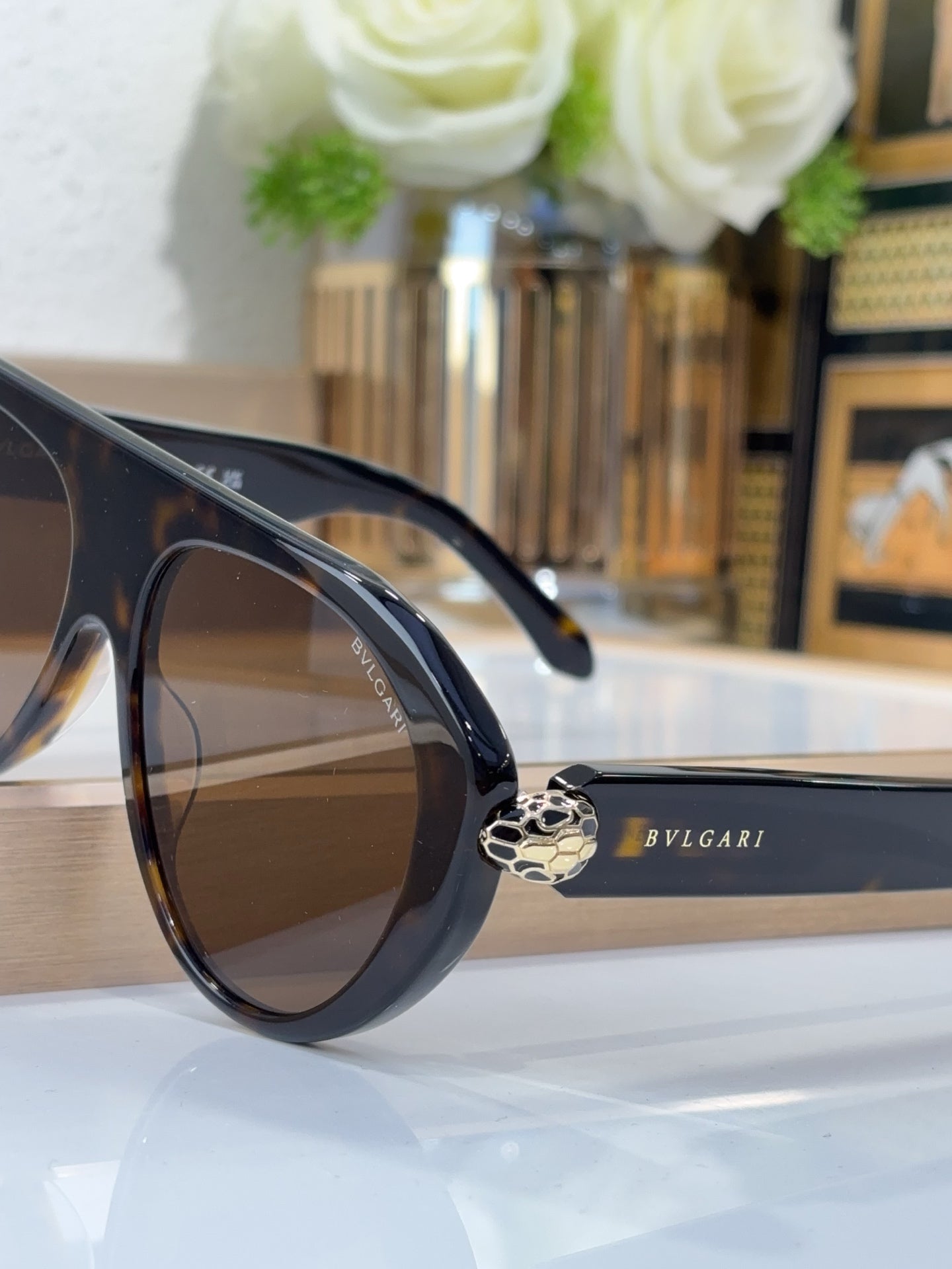 Bvlgari sunglasses with dark frames and brown lenses, side view with emblem bridge detail