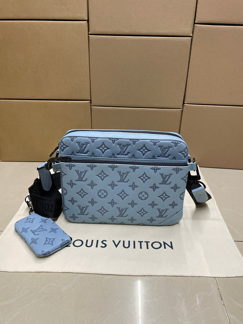 Light blue monogram crossbody bag with zipper top and adjustable shoulder strap