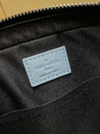 Light blue logo patch on black interior fabric of monogram crossbody bag
