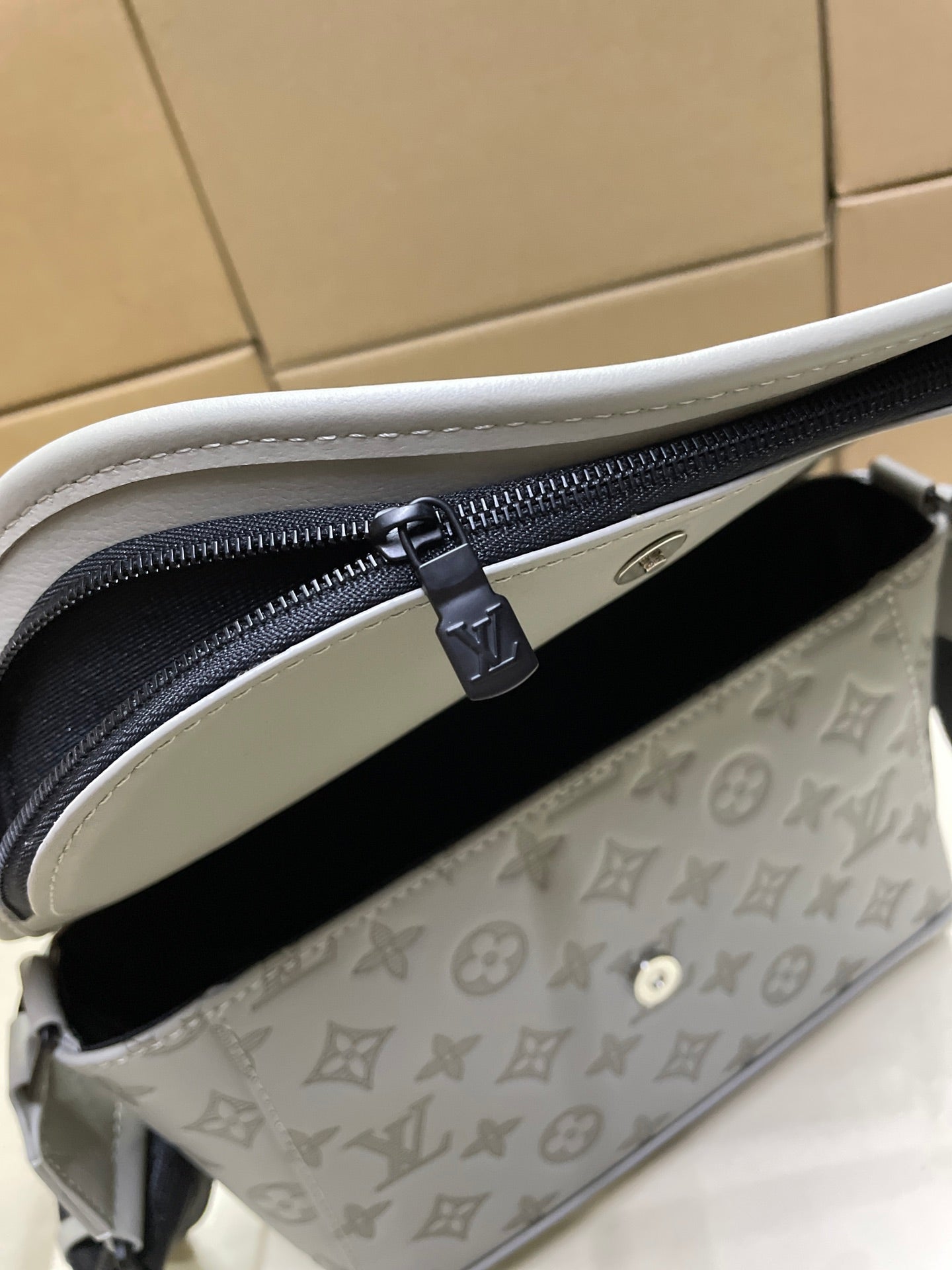 Louis Vuitton men’s crossbody bag interior view, zipper track and dark lining