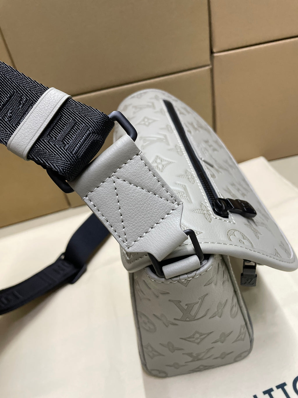 Louis Vuitton crossbody bag with strap attachment and monogram pattern on the flap