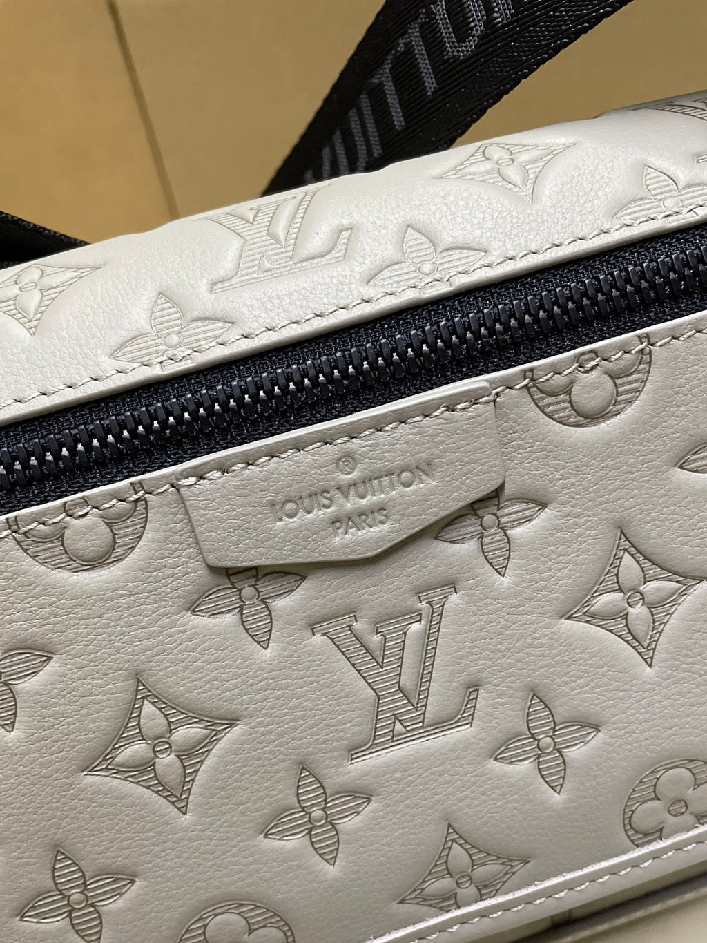 Louis Vuitton men’s crossbody bag, close-up of embossed monogram leather and zipper