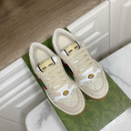 Cream Gucci unisex sneakers with lace-up front and multicolor stripe, pair view