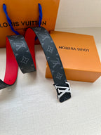 Navy monogram belt with metal buckle hardware and red-lined underside
