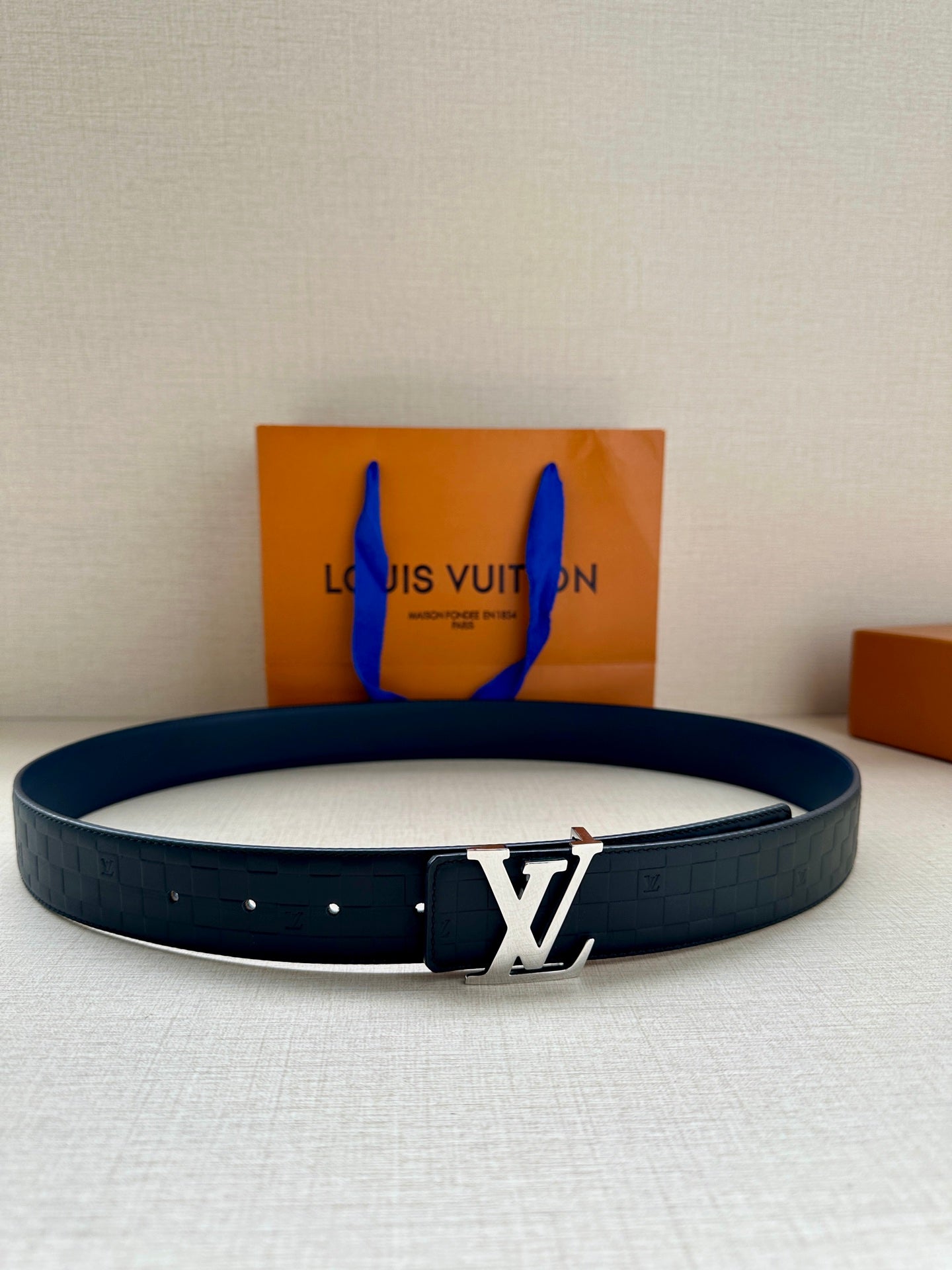 Blue embossed leather belt with silver LV logo buckle.