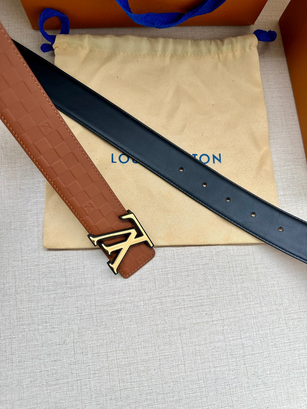 Louis Vuitton belt with dark navy strap, embossed leather edge, gold-tone LV buckle