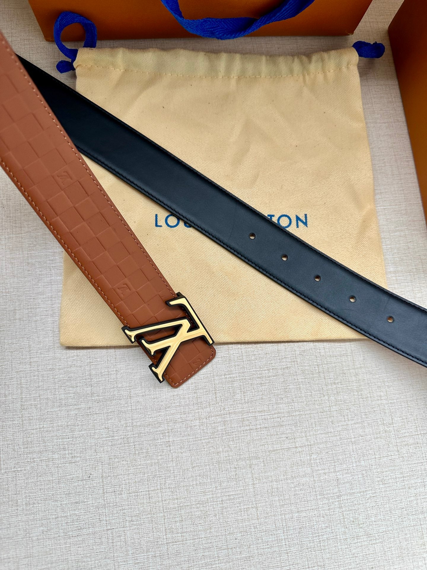 Louis Vuitton belt with dark navy strap, embossed leather edge, gold-tone LV buckle
