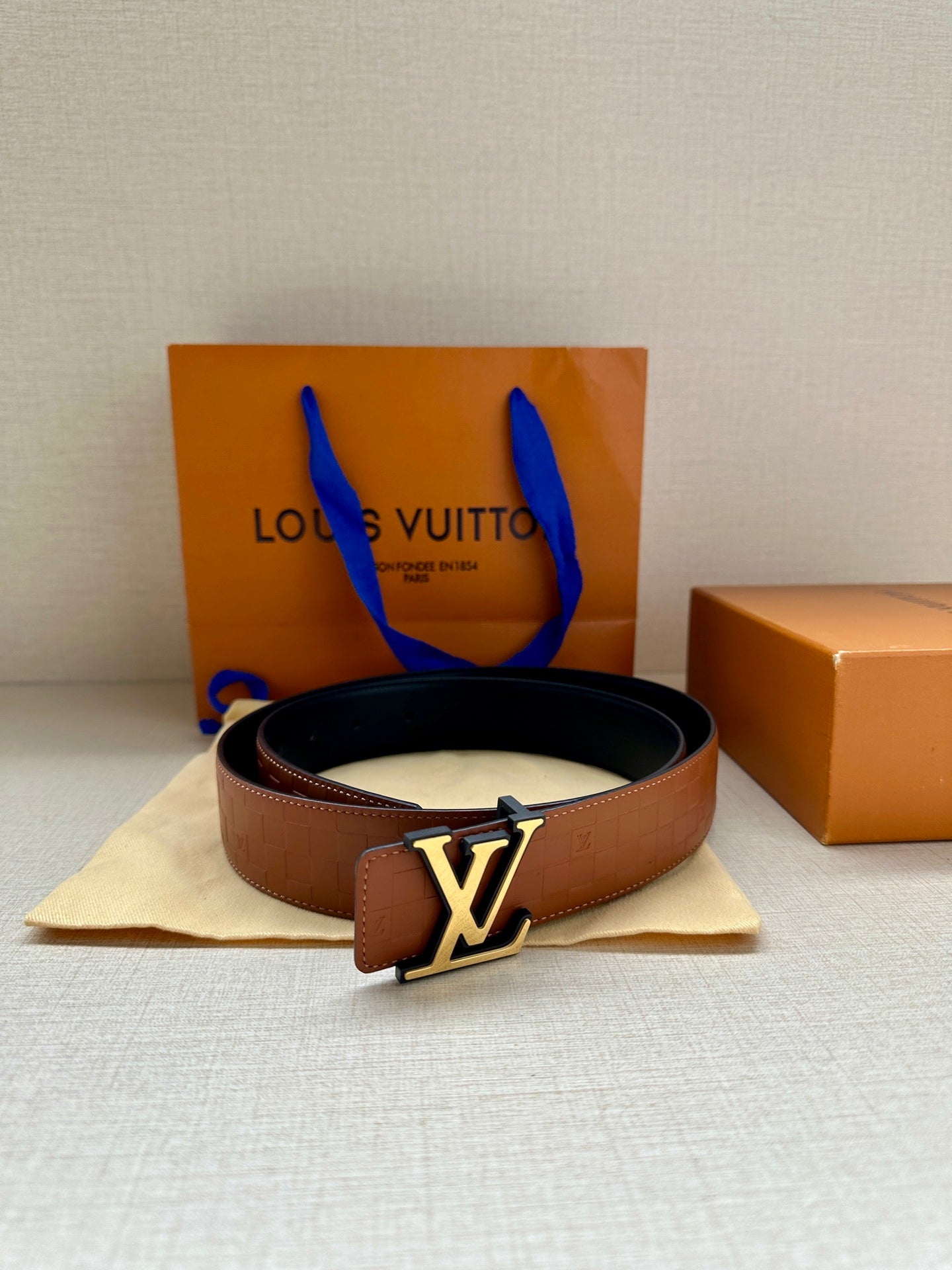 Louis Vuitton dark brown belt with gold-tone LV buckle on fabric pouch