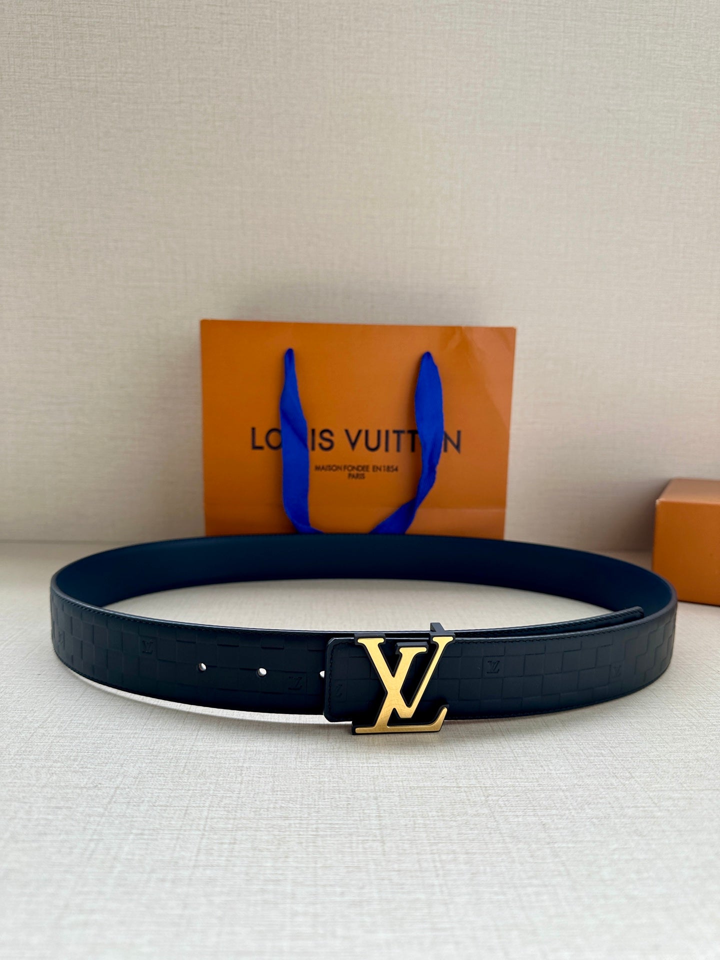 Louis Vuitton belt in dark blue with embossed pattern and gold LV buckle