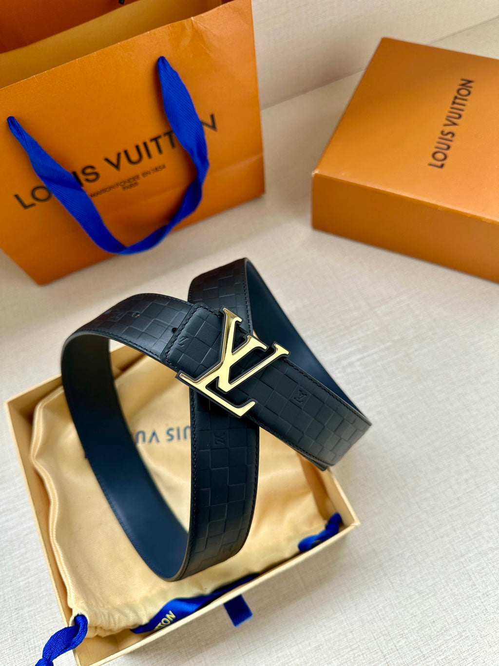 Louis Vuitton belt on pouch: dark blue embossed strap with gold LV buckle