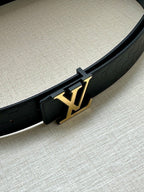 Louis Vuitton belt detail: dark blue strap with gold LV buckle and embossed texture