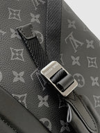 Close-up of adjustable strap and metal connector on dark monogram backpack