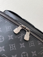 Close-up of dark monogram backpack zipper pull and metal pull tabs
