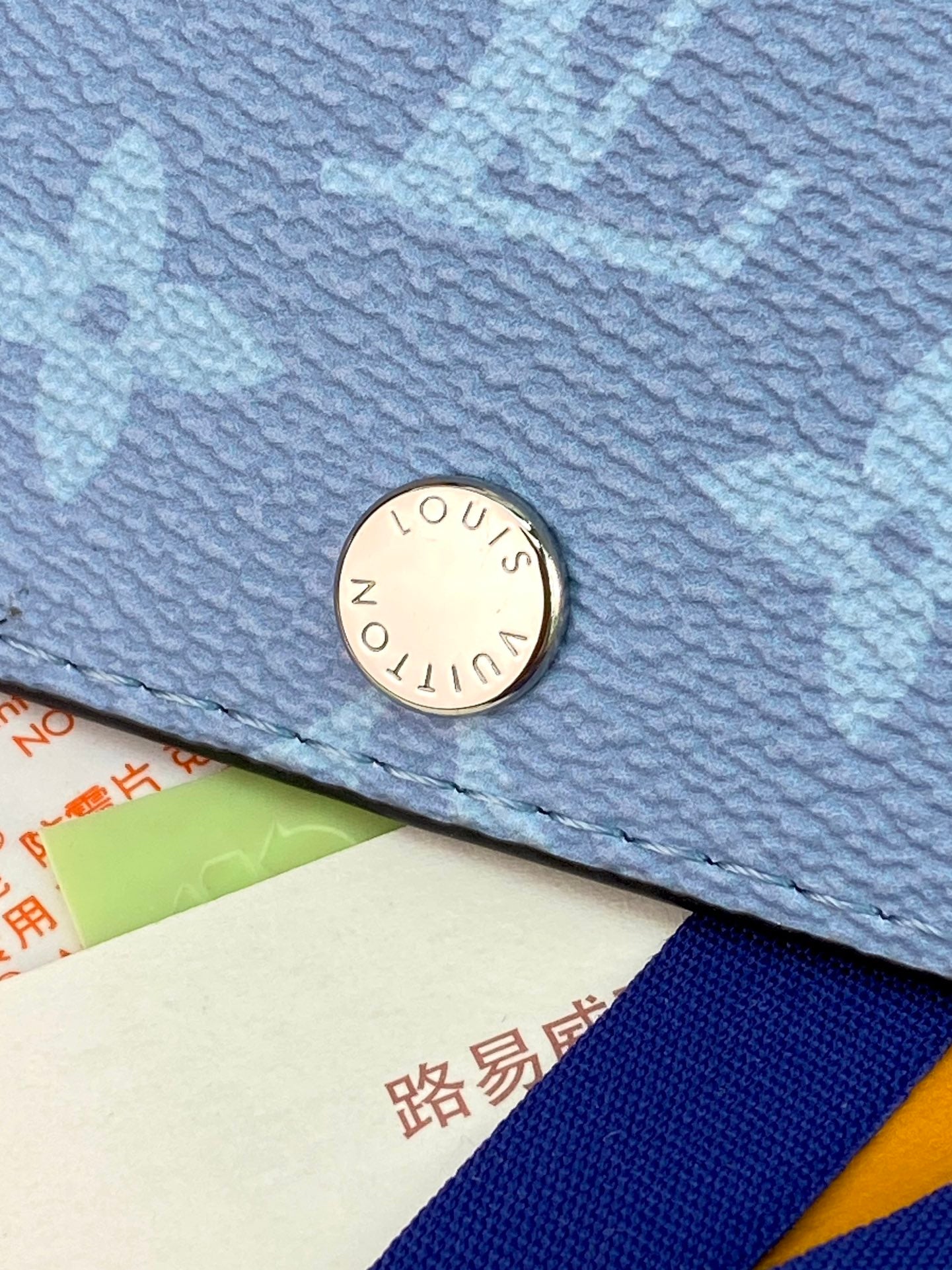 Blue small bag with round metal logo snap closure