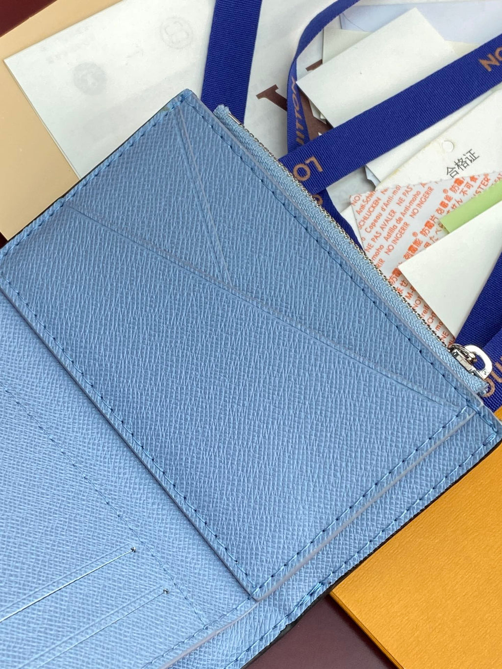 Light blue Louis Vuitton small bag with stitched edge and monogram flap corner detail